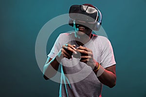 Modern gamer playing video game with joystick and vr headset