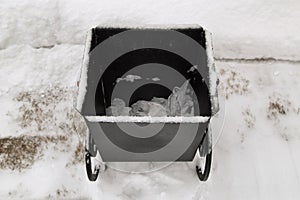 Modern garbage bin in snow top view.