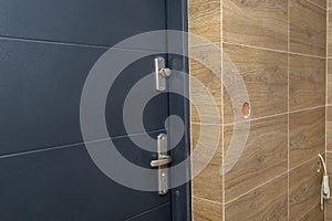 Modern gas boiler room with brown ceramic tiles imitating wood, empty room without installation, visible entrance door to the boil