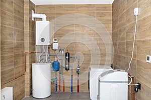 A modern gas boiler room lined with ceramic tiles imitating wood, visible full boiler room equipment with a washing machine and wa