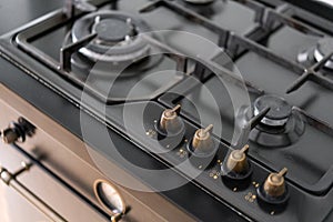 Modern gas burner and hob on a kitchen range. Dark black color and wooden Small kitchen in a modern apartment