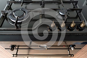 Modern gas burner and hob on a kitchen range. Dark black color and wooden Small kitchen in a modern apartment