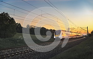 Modern German train traveling at sunset