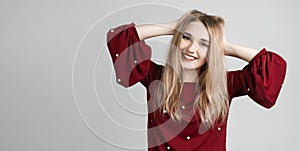 Modern girl with long blonde hair holding to her head or touching hair.  on white background