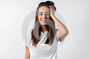 Modern girl with long chestnut hair holding to her head or touching hair.  on white background