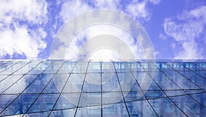Modern glass building. Cloudy sky background, under view, space.