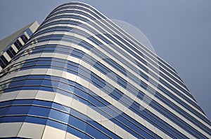 Modern glass building soaring into blue sky