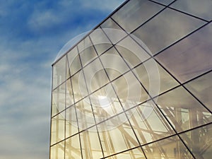 Modern glass building under the blue sky.Sun rays light effects on urban buildings. Abstract image of looking up at modern