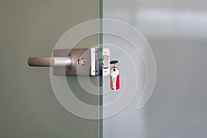 Modern glass door with metal alloy handles and key chain in lock, home or office security concept