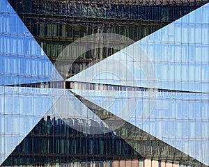 Modern glass facade in Berlin with reflections of skyline and pavement