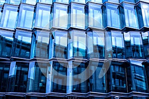 Modern glass facade of an office building, reflection of the sky in the Windows