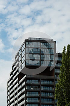 Modern glass office building exterior with glass facade on clear sky background. Transparent glass wall of office