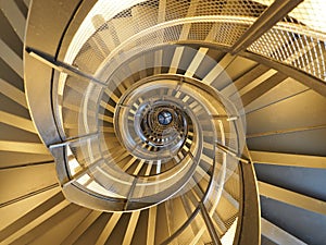 Modern, golden spiral staircase which gives an hypnotic view