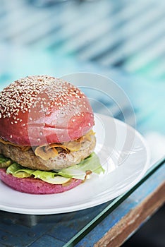 Modern gourmet chicken burger in beetroot bun