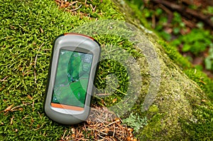 Modern GPS navigation on the floor of green forest