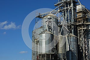 Modern grain terminal. Metal tanks of elevator. Grain-drying complex construction. Commercial grain or seed silos at