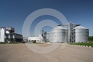 Modern granary in animal feed factory. Agro-industry storage technology. Big metal containers for grain storage