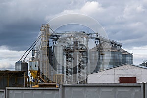 Modern granary elevator and seed cleaning line in silver silos on agro-processing and manufacturing plant for storage and