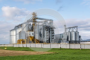 Modern granary elevator and seed cleaning line in silver silos on agro-processing and manufacturing plant for storage and