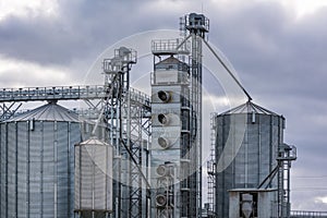 Modern granary elevator and seed cleaning line in silver silos on agro-processing and manufacturing plant for storage and