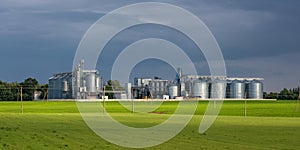 Modern Granary elevator and seed cleaning line. Silver silos on agro-processing and manufacturing plant for storage and processing