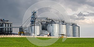 Modern Granary elevator and seed cleaning line. Silver silos on agro-processing and manufacturing plant for storage and processing