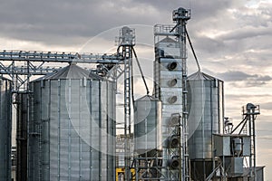 Modern Granary elevator and seed cleaning line. Silver silos on agro-processing and manufacturing plant for storage and processing