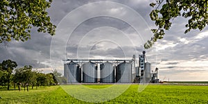 Modern Granary elevator and seed cleaning line. Silver silos on agro-processing and manufacturing plant for storage and processing