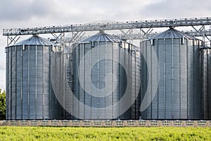 Modern Granary elevator and seed cleaning line. Silver silos on agro-processing and manufacturing plant for storage and processing