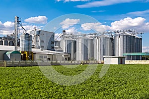 Modern Granary elevator. Silver silos on agro-processing and manufacturing plant for processing drying cleaning and storage of