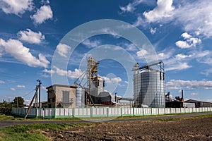 Modern Granary elevator. Silver silos on agro-processing and manufacturing plant for processing drying cleaning and storage of