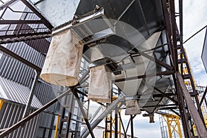 Modern Granary elevator. Silver silos on agro-processing and manufacturing plant for processing drying cleaning and storage of