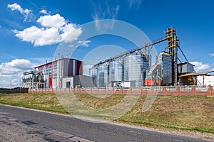 Modern Granary elevator. Silver silos on agro-processing and manufacturing plant for processing drying cleaning and storage of