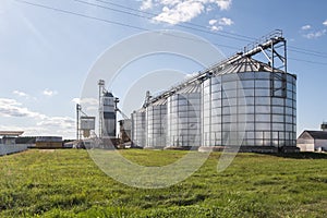 Modern Granary elevator. Silver silos on agro-processing and manufacturing plant for processing drying cleaning and storage of
