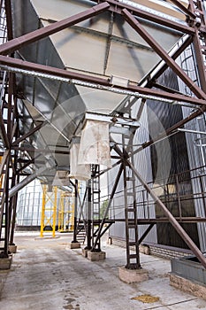 Modern Granary elevator. Silver silos on agro-processing and manufacturing plant for processing drying cleaning and storage of