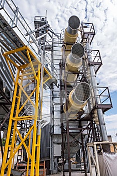 Modern Granary elevator. Silver silos on agro-processing and manufacturing plant for processing drying cleaning and storage of