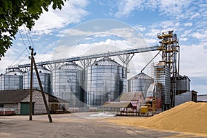 Modern Granary elevator. Silver silos on agro-processing and manufacturing plant for processing drying cleaning and storage of