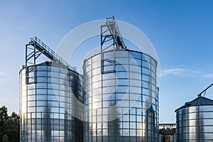 Modern Granary elevator with silver silos on agro-processing and manufacturing plant for processing drying cleaning and storage of