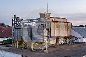 Modern Granary elevator with silver silos on agro-processing and manufacturing plant for processing drying cleaning and storage of