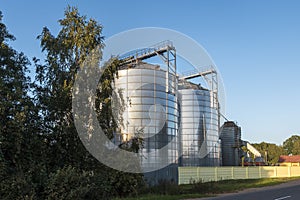 Modern Granary elevator with silver silos on agro-processing and manufacturing plant for processing drying cleaning and storage of