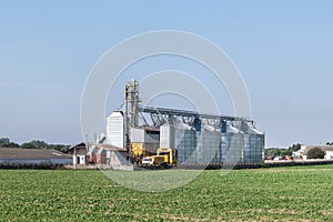 Modern Granary elevator with silver silos on agro-processing and manufacturing plant for processing drying cleaning and storage of