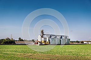 Modern Granary elevator. Silver silos on agro-processing and manufacturing plant for processing drying cleaning and storage of