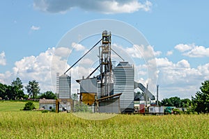 Modern Granary elevator. Silver silos on agro-processing and manufacturing plant for processing drying cleaning and storage of