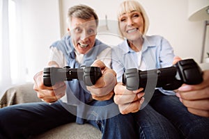 Modern grandparents. Senior couple playing video games