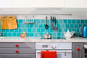 Modern gray kitchen features dark gray flat front cabinets paired with white quartz countertops