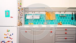 Modern gray kitchen features dark gray flat front cabinets paired with white quartz countertops