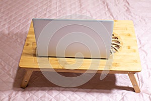 Modern gray thin laptop on the wooden Cooling pad for laptop..Notebook Cooler  for Computer, USB Fan. Work with laptop on the bed photo