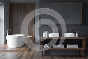 Modern grey bathroom with oval white bathtub and dark wood details
