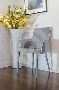 Modern grey chair with yellow flower in vase