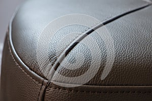 Modern Grey leather footstool, closeup view.